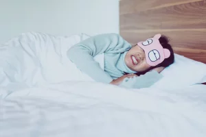 Female dental patient in bed with sleeping mask